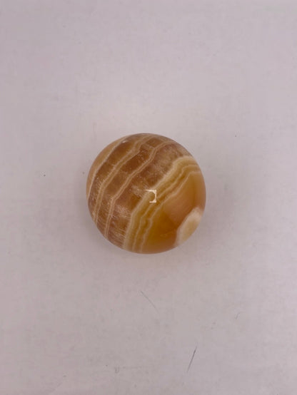 Honey calcite spheres available at wholesale and retail prices, only at our crystal shop in San Diego!